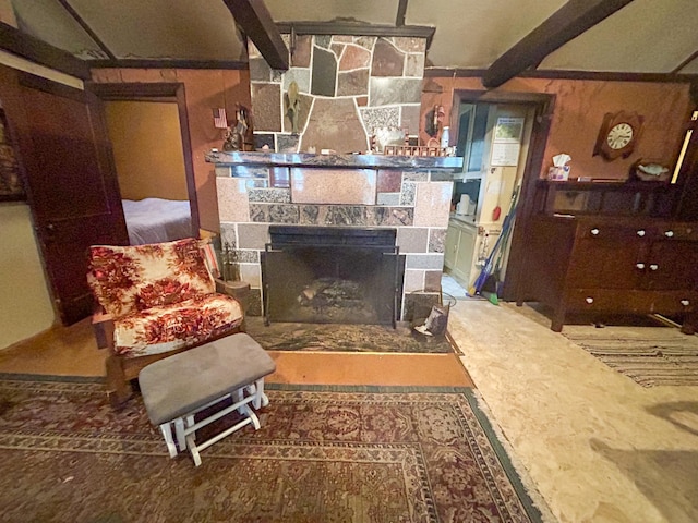 living room featuring beamed ceiling and a fireplace