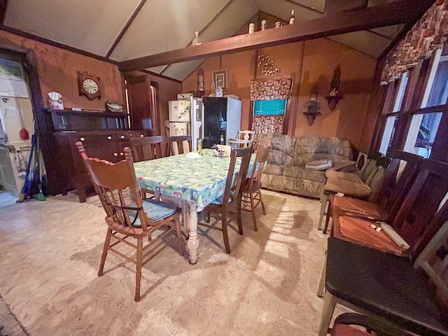 dining space with lofted ceiling with beams