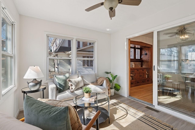 interior space with visible vents, wood finished floors, baseboards, and ceiling fan