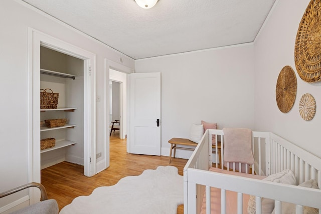 bedroom with a textured ceiling and wood finished floors