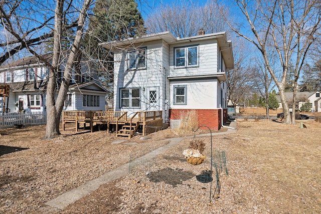 rear view of property with a wooden deck and a chimney