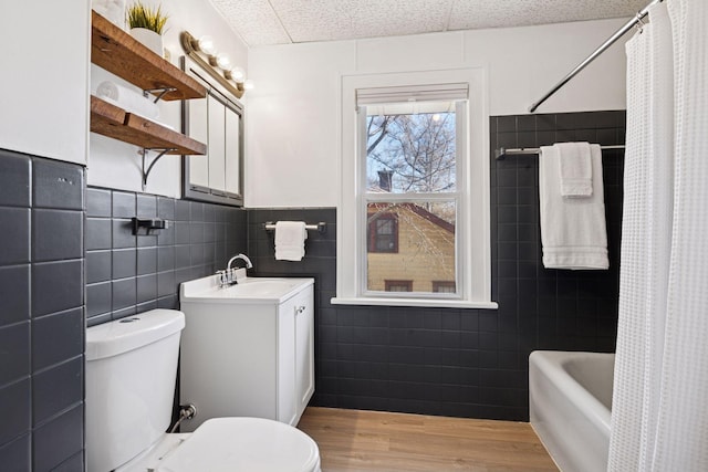 bathroom featuring vanity, toilet, wood finished floors, and shower / tub combo with curtain