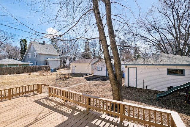 wooden deck featuring an outdoor structure and a playground