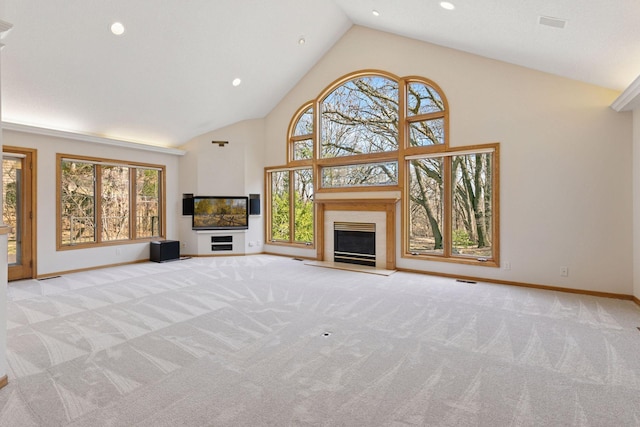 unfurnished living room featuring plenty of natural light, baseboards, and carpet flooring