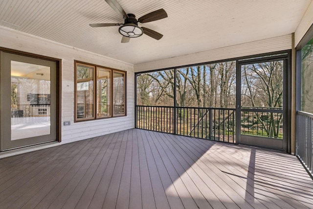 unfurnished sunroom featuring a ceiling fan