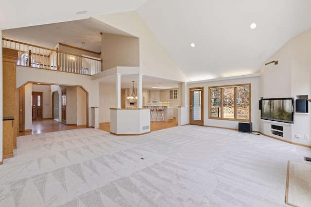 unfurnished living room with recessed lighting, visible vents, light carpet, baseboards, and high vaulted ceiling