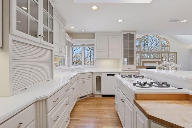 kitchen featuring white cabinetry, light wood-style floors, white appliances, and recessed lighting
