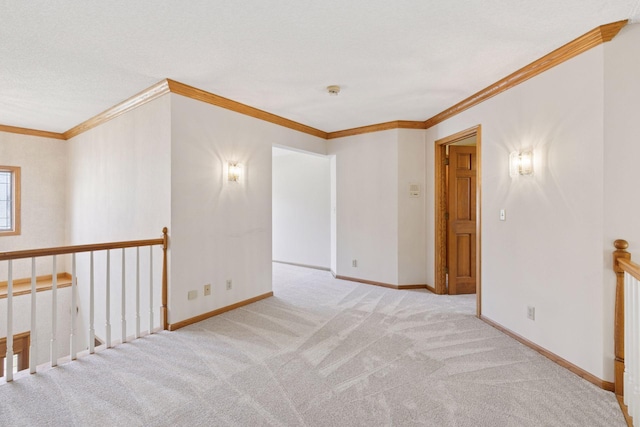 carpeted empty room with baseboards and crown molding