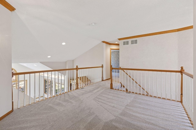 corridor with lofted ceiling, visible vents, carpet flooring, and an upstairs landing