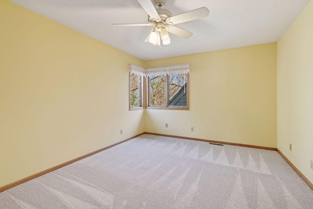 empty room featuring light carpet, baseboards, visible vents, and ceiling fan