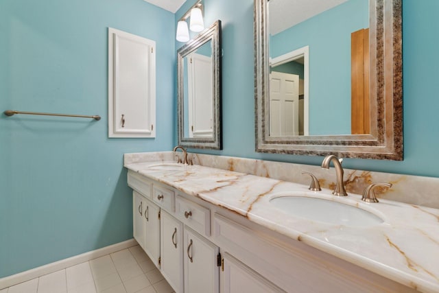 bathroom with tile patterned floors, baseboards, a sink, and double vanity