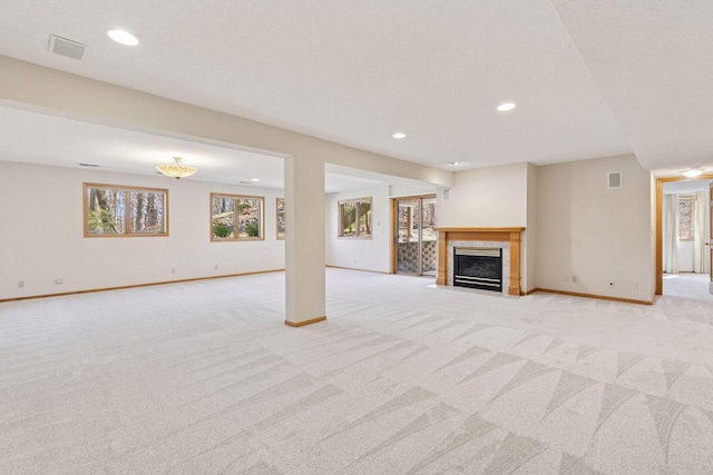 unfurnished living room featuring light carpet, a tile fireplace, baseboards, visible vents, and recessed lighting
