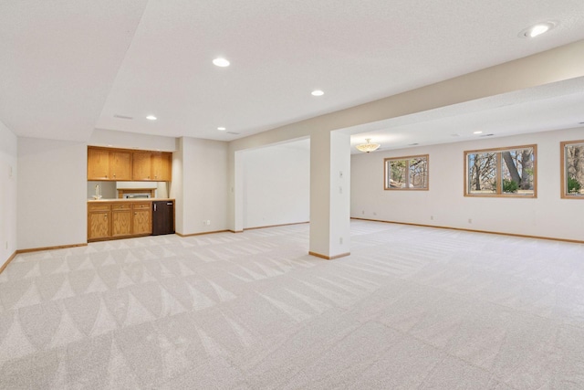 unfurnished living room with light colored carpet, baseboards, and recessed lighting
