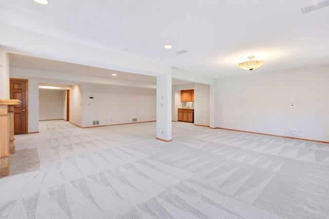 finished below grade area featuring recessed lighting, baseboards, visible vents, and light colored carpet