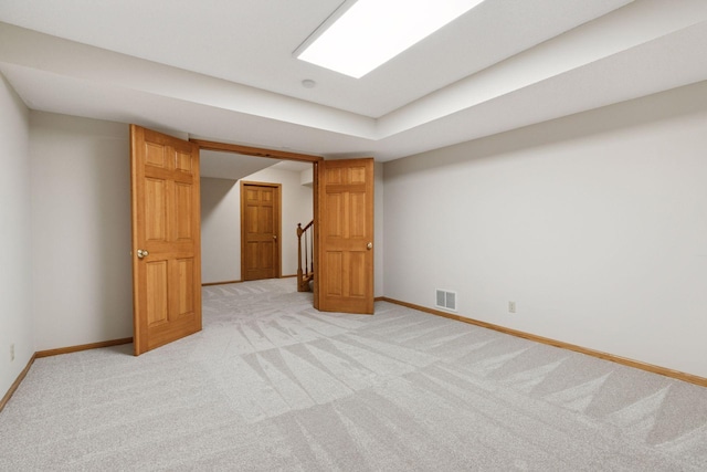 finished basement featuring light colored carpet, baseboards, and visible vents