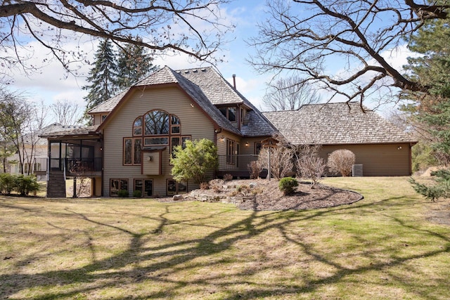 rear view of property featuring a sunroom and a lawn