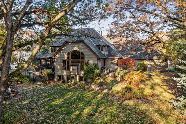 view of front of property featuring a front lawn, stairs, and a deck