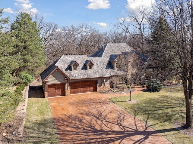 rustic home featuring stone siding, concrete driveway, a front lawn, and a garage