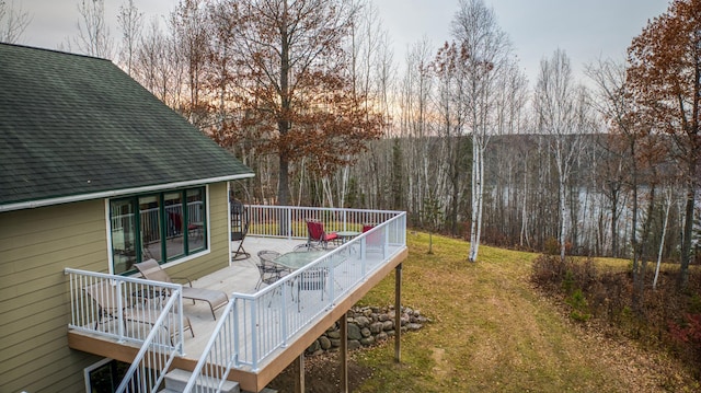 deck at dusk featuring a yard