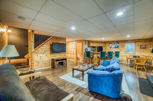 living room featuring wood-type flooring and wooden walls