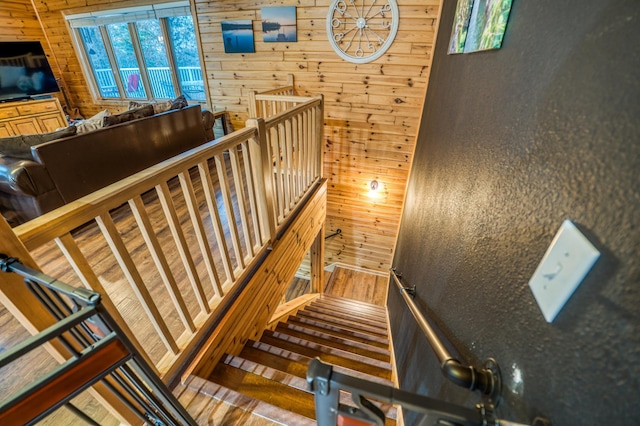 stairway featuring wood walls