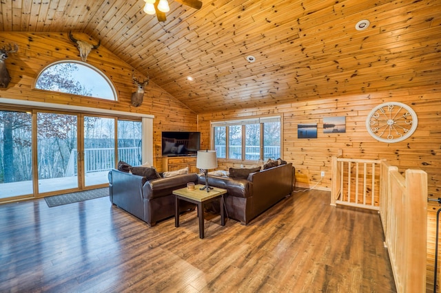 living room featuring wood ceiling, ceiling fan, wooden walls, wood-type flooring, and high vaulted ceiling