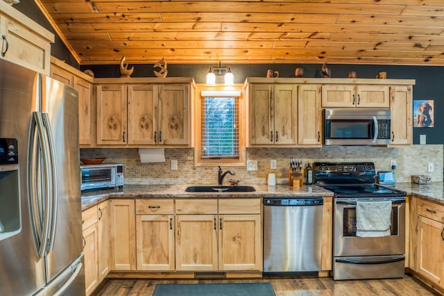 kitchen featuring wooden ceiling, dark stone counters, sink, vaulted ceiling, and stainless steel appliances