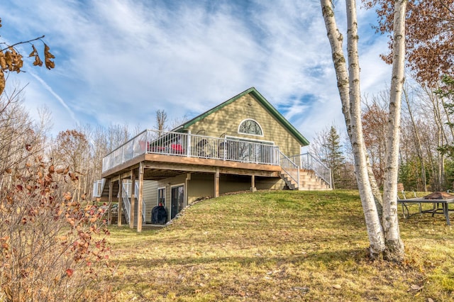 rear view of property featuring a yard and a deck