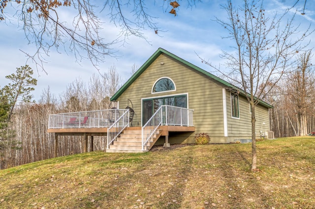 rear view of house featuring a yard, a deck, and central AC unit