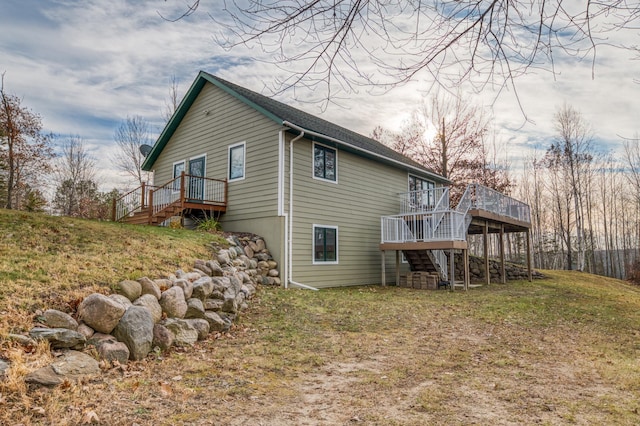 rear view of property with a lawn and a deck