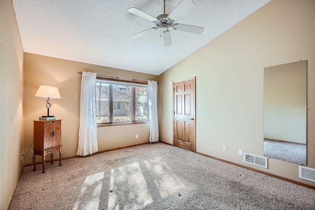 unfurnished bedroom with lofted ceiling, a textured ceiling, carpet flooring, and ceiling fan