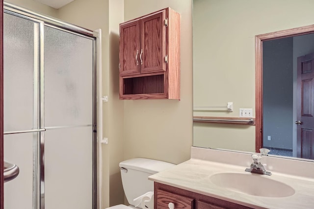 bathroom with an enclosed shower, vanity, and toilet