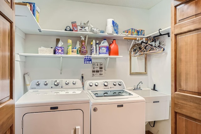 clothes washing area with separate washer and dryer, a textured ceiling, and sink