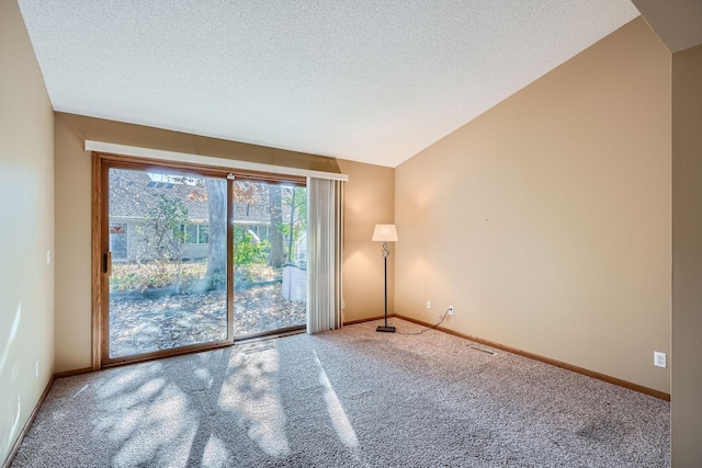 spare room featuring carpet flooring, a textured ceiling, and vaulted ceiling