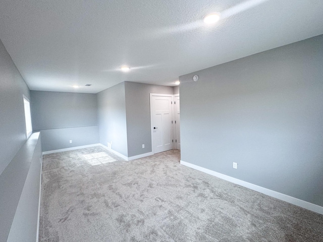 unfurnished room featuring a textured ceiling and carpet floors