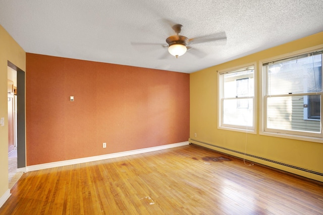 unfurnished room featuring light hardwood / wood-style flooring, a baseboard heating unit, a textured ceiling, and ceiling fan