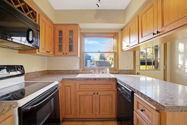 kitchen with light tile patterned floors, black appliances, sink, and kitchen peninsula