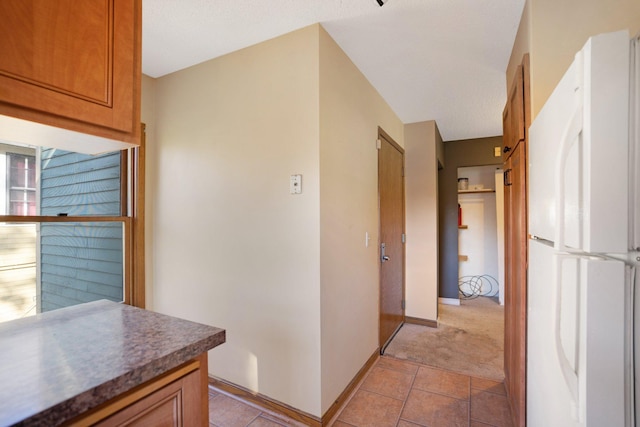 interior space featuring a textured ceiling and light colored carpet