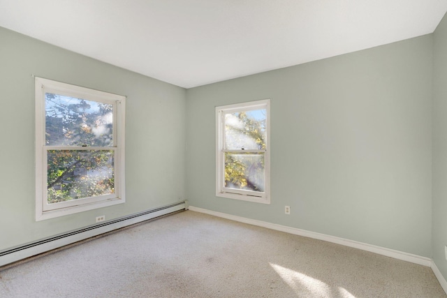 empty room featuring baseboard heating and light colored carpet