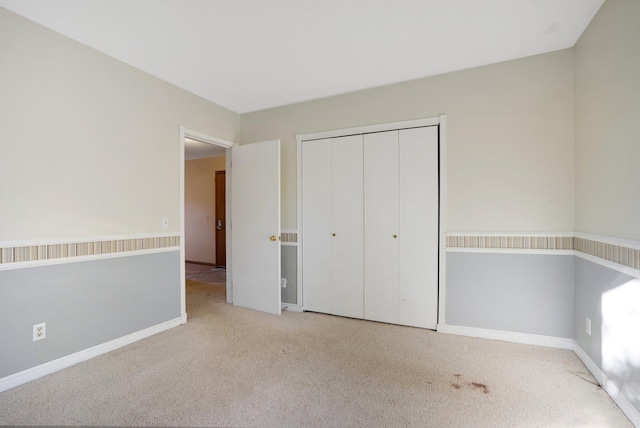 unfurnished bedroom with light carpet and a closet