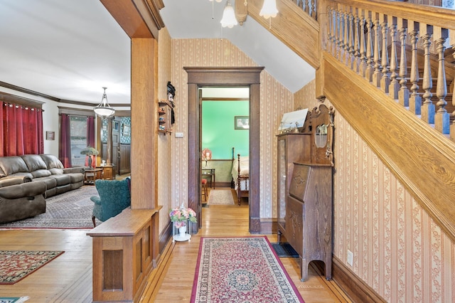 corridor featuring ornamental molding and light hardwood / wood-style flooring