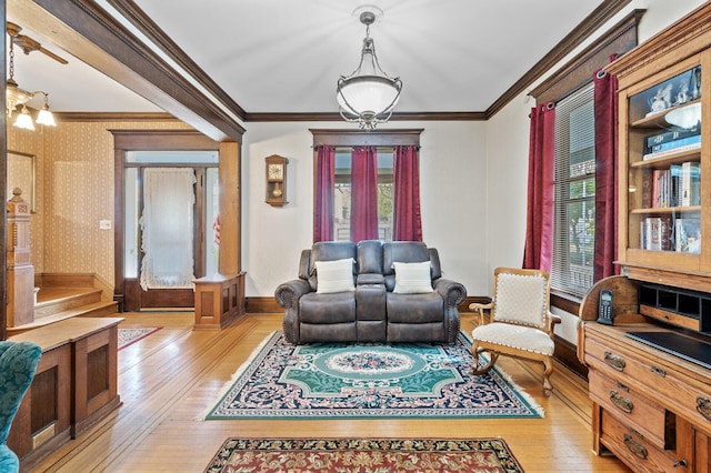 living room featuring crown molding, light hardwood / wood-style floors, and decorative columns