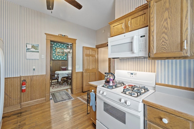 kitchen with white appliances, ceiling fan, and light wood-type flooring