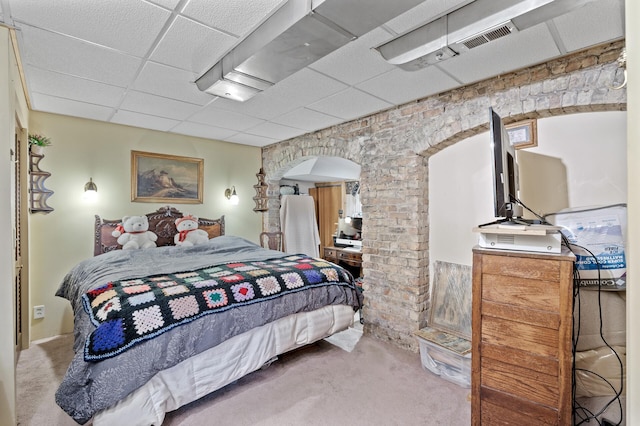 bedroom with a paneled ceiling and light colored carpet