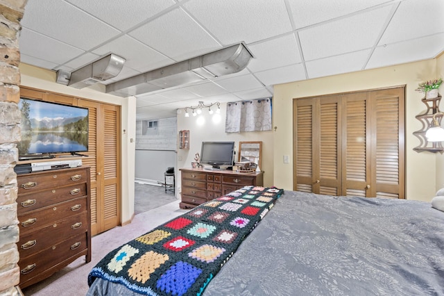 carpeted bedroom featuring a closet and a paneled ceiling