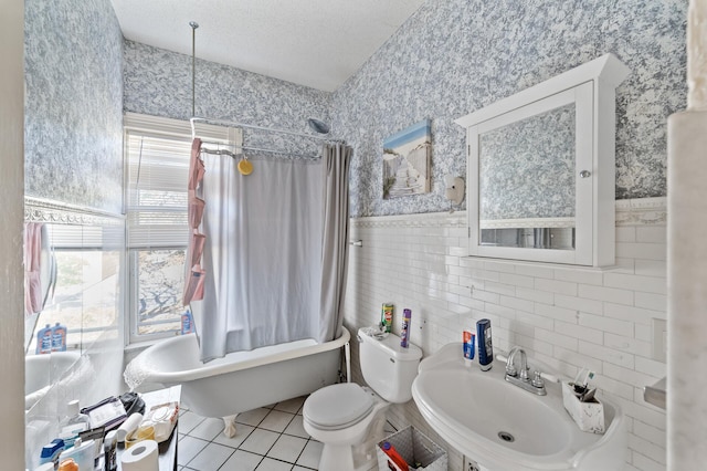 full bathroom featuring toilet, shower / bath combo, sink, and tile walls