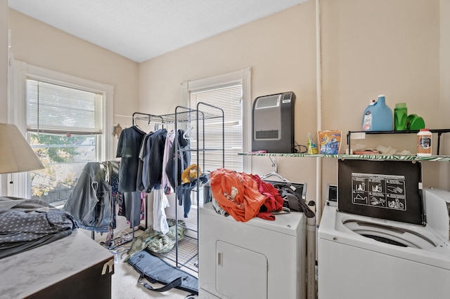 laundry area featuring a textured ceiling, washer and clothes dryer, carpet flooring, and plenty of natural light