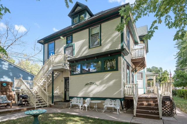 rear view of property with a patio and a balcony