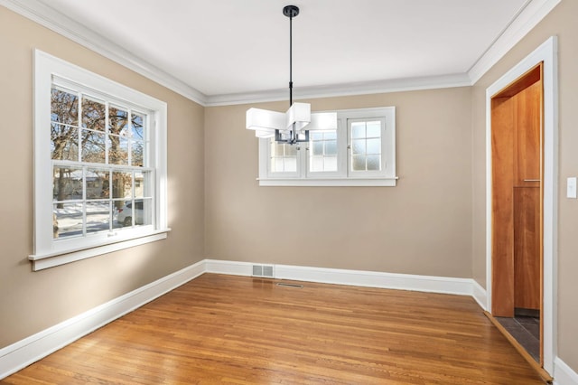 unfurnished dining area with ornamental molding, visible vents, and wood finished floors