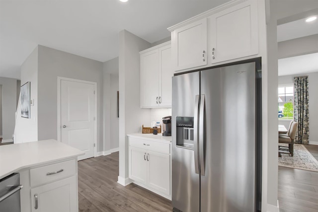 kitchen featuring white cabinets, stainless steel fridge with ice dispenser, and dark hardwood / wood-style flooring